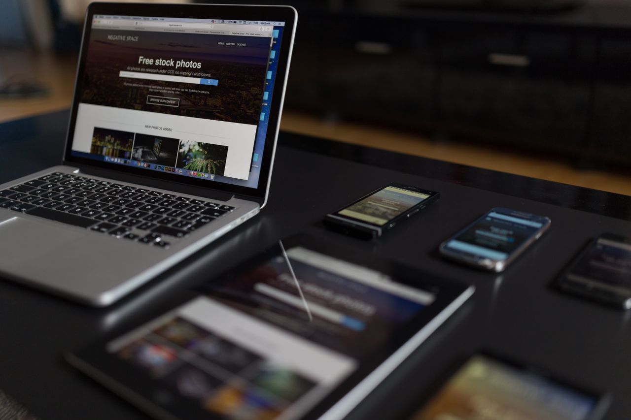 Un espace de travail moderne présentant un ordinateur portable, une tablette et des smartphones, idéal pour les usages tech et freelance.